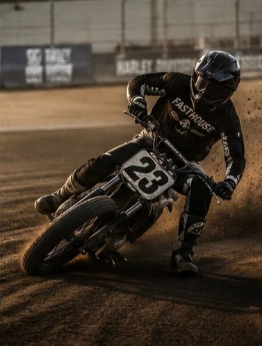 Flat track motorcycle racers cornering on a dirt oval